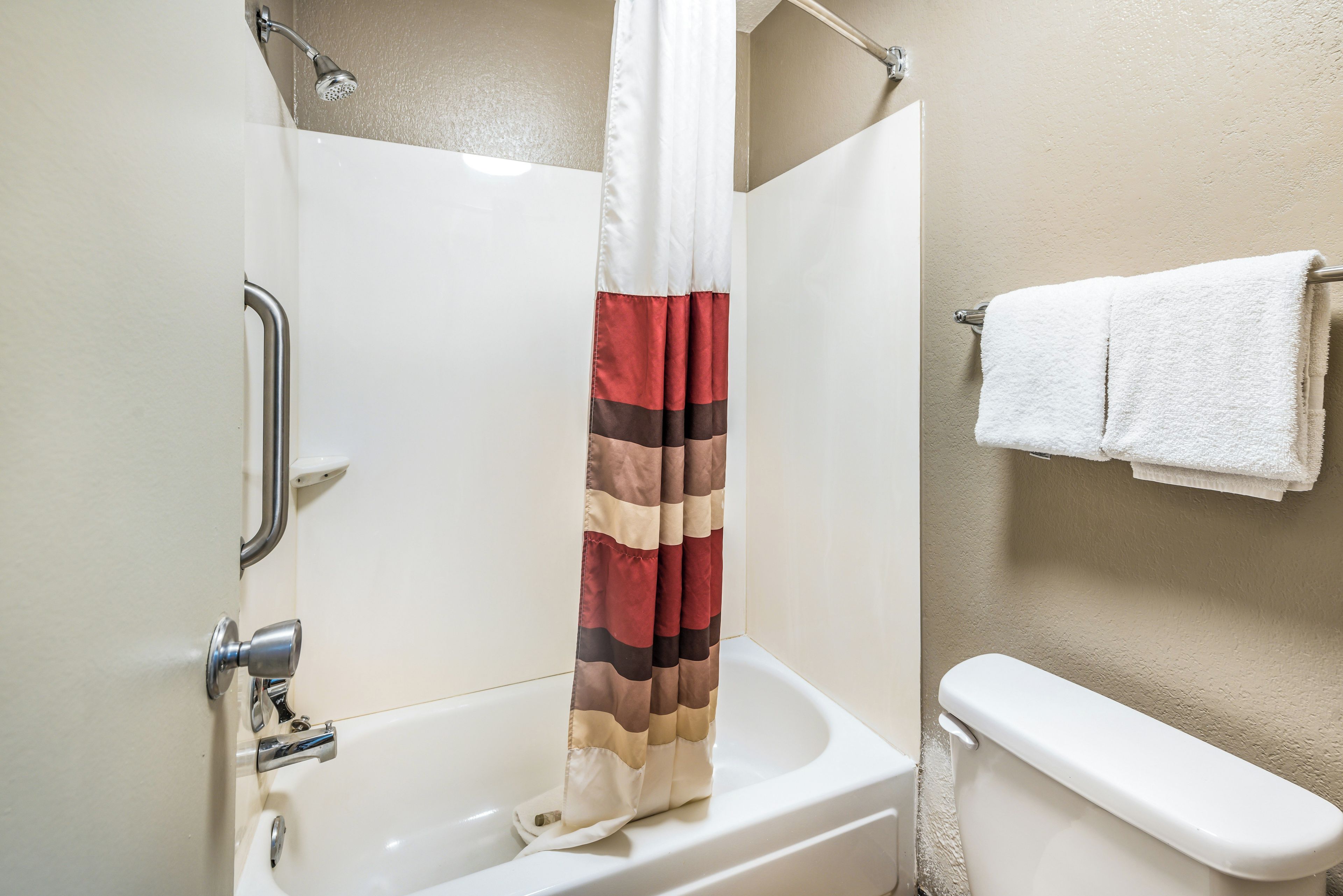 Un baño con bañera, cortina de ducha y barra para toallas.