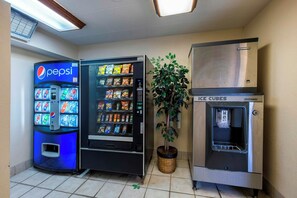 Zona de máquinas expendedoras con refrigerador de Pepsi, diversas opciones de bocadillos y dispensador de hielo.