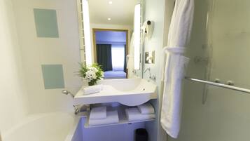 A modern bathroom with a bathtub, a sink with a mirror, and a shower.