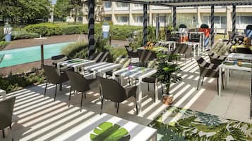 Una piscina al aire libre, sombrillas, sillones reclinables de piscina