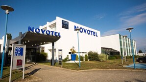 A hotel with a modern design, featuring the name 'NOVOTEL' prominently displayed on the facade.