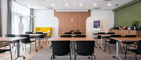 A modern conference room with a large table, black chairs, a patterned carpet, and a wooden accent wall.