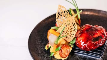 A dish with various vegetables and a decorative element on a dark plate.