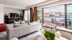 A modern living room with a sofa, TV, and a balcony with outdoor seating. - Sofitel Lisbon Liberdade (Lisbon)