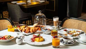 A breakfast buffet with various dishes, drinks, and a coffee setup. - Sofitel Lisbon Liberdade (Lisbon)