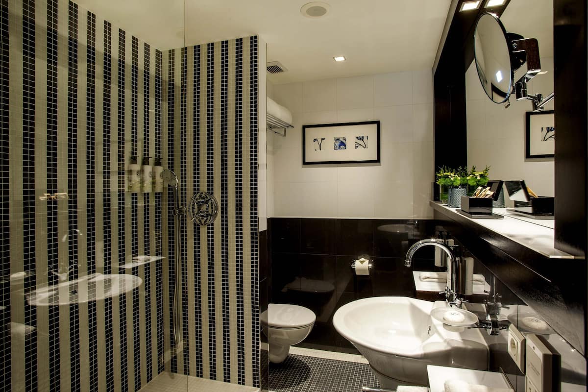 Een bad/douchecombinatie, een regendouche, designer toiletartikelen