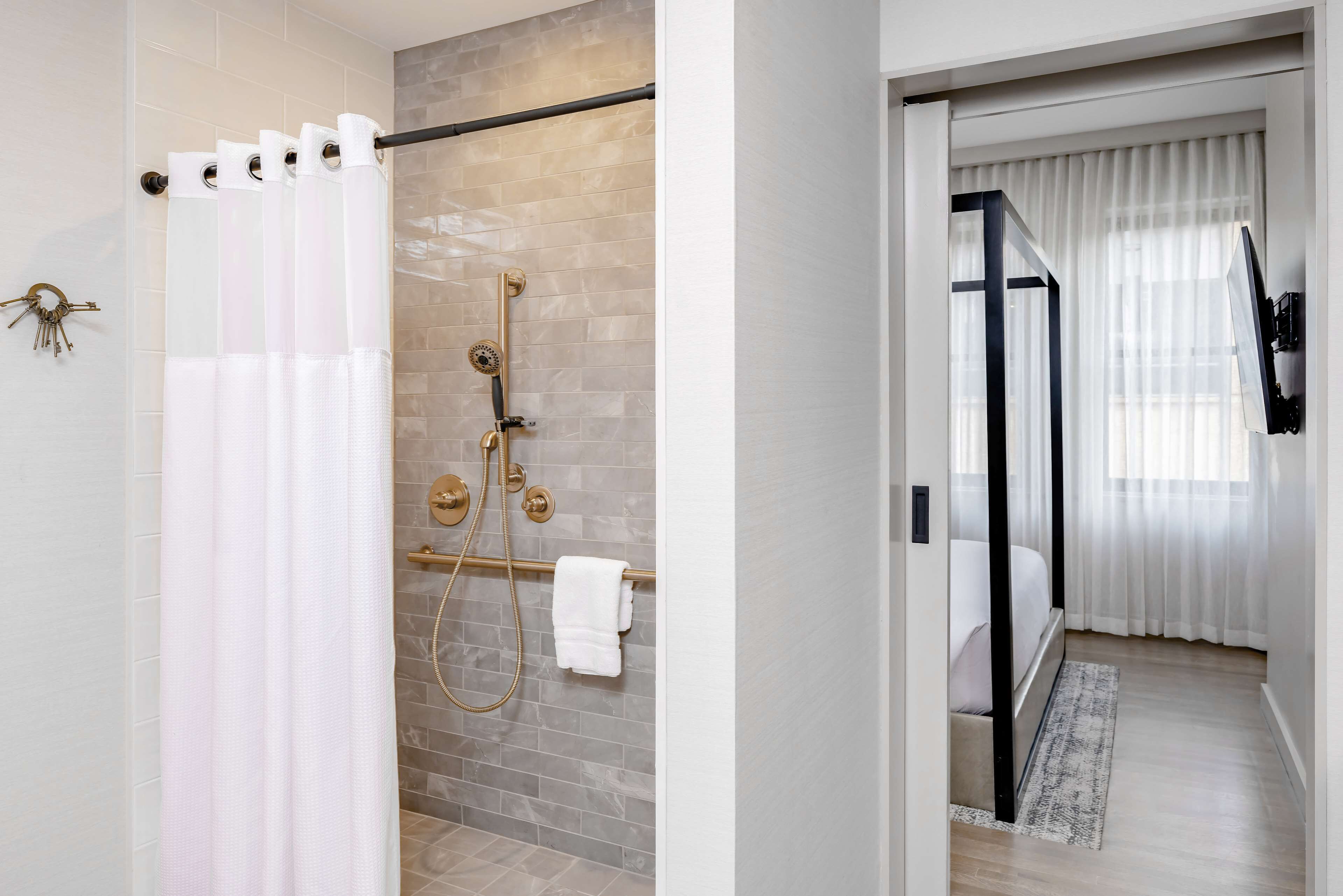 A modern bathroom with a shower, a towel rack, and a glass shower door.