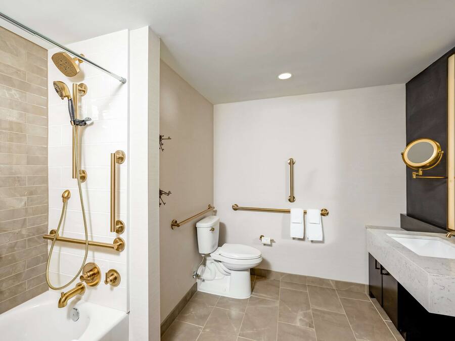 A modern bathroom with a bathtub, shower, toilet, and vanity.