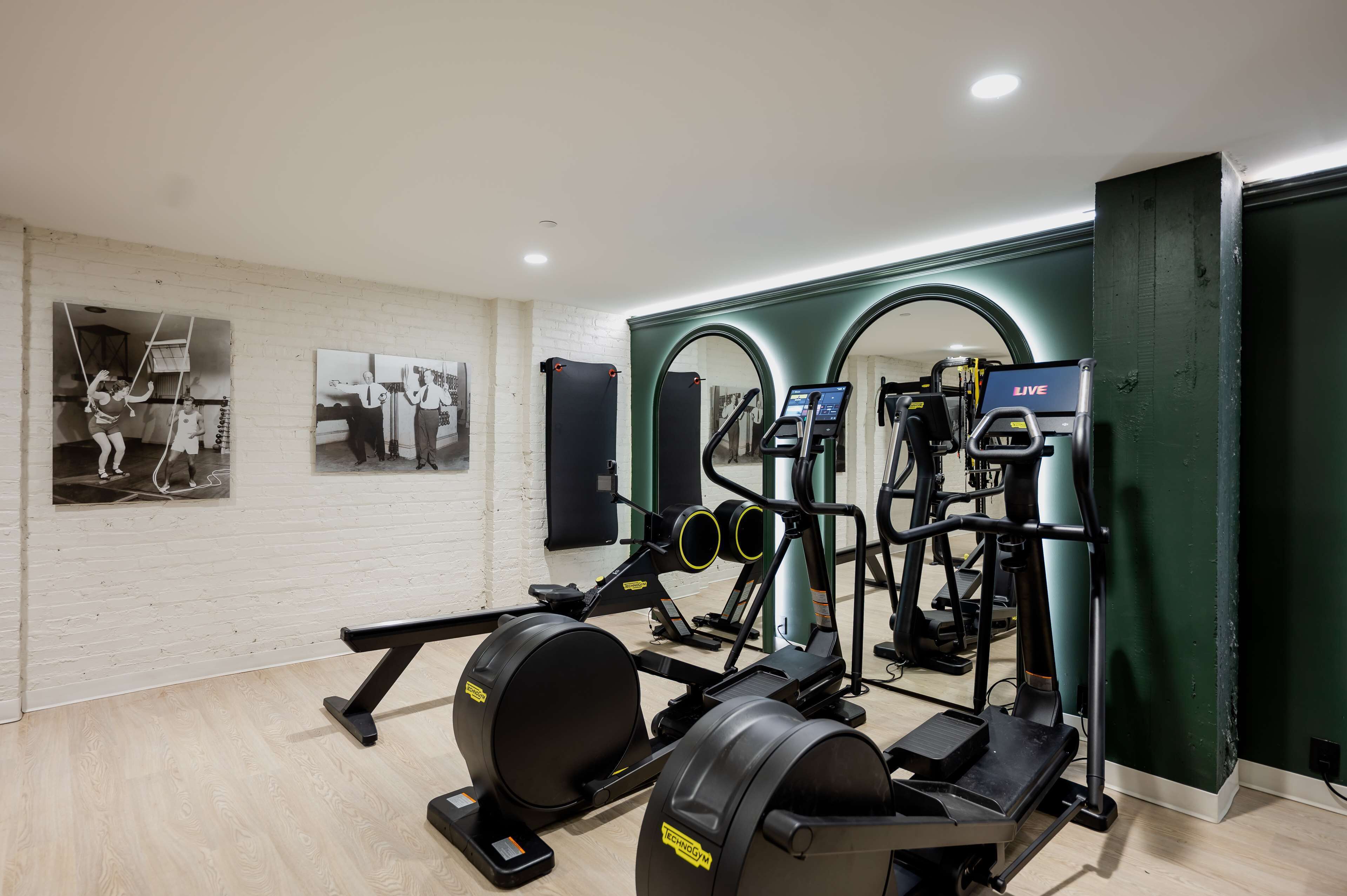 A gym with exercise equipment, including a treadmill, elliptical, and weight machines.