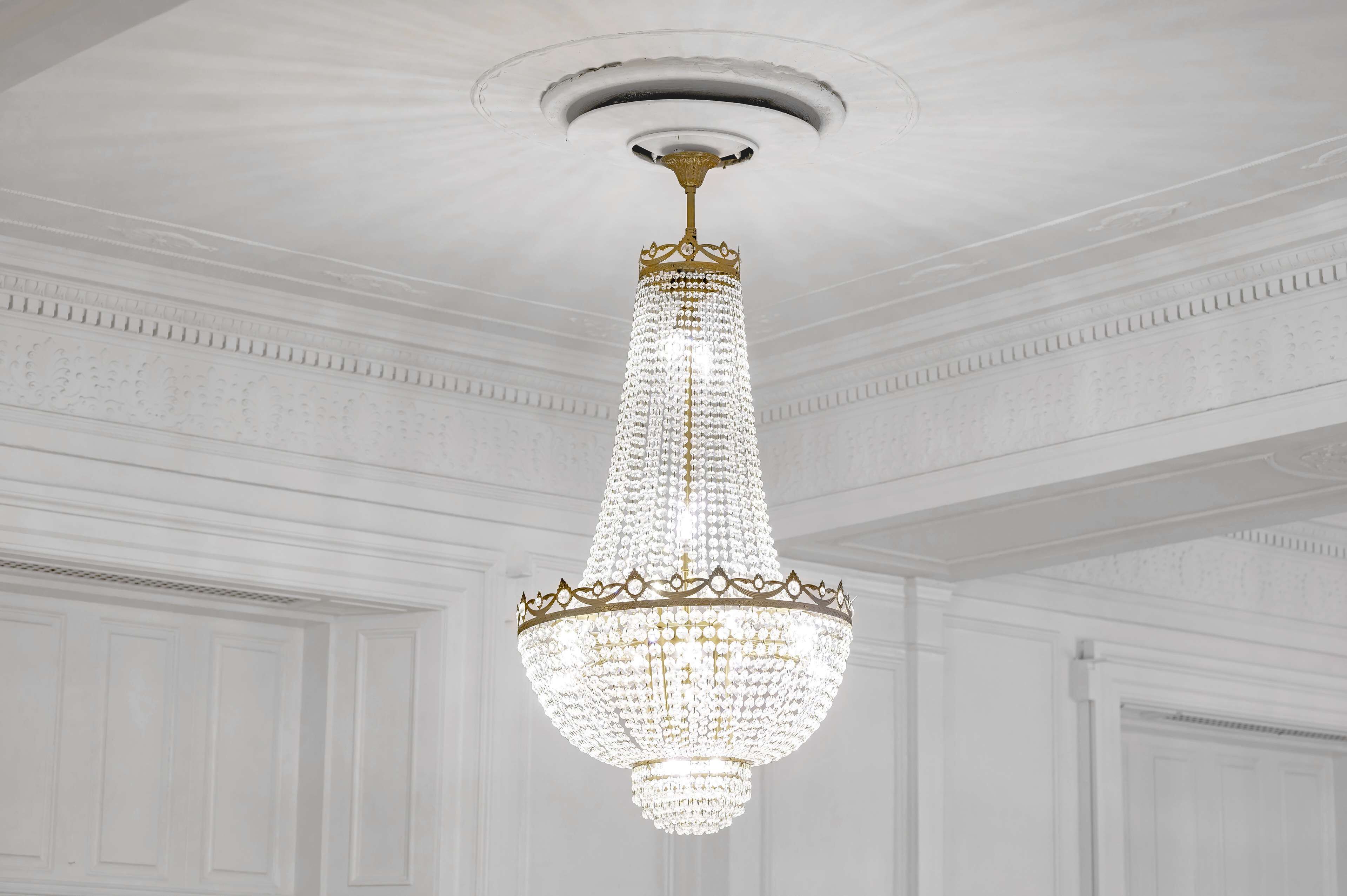 Um candelabro com estrutura dourada e detalhes em cristal.