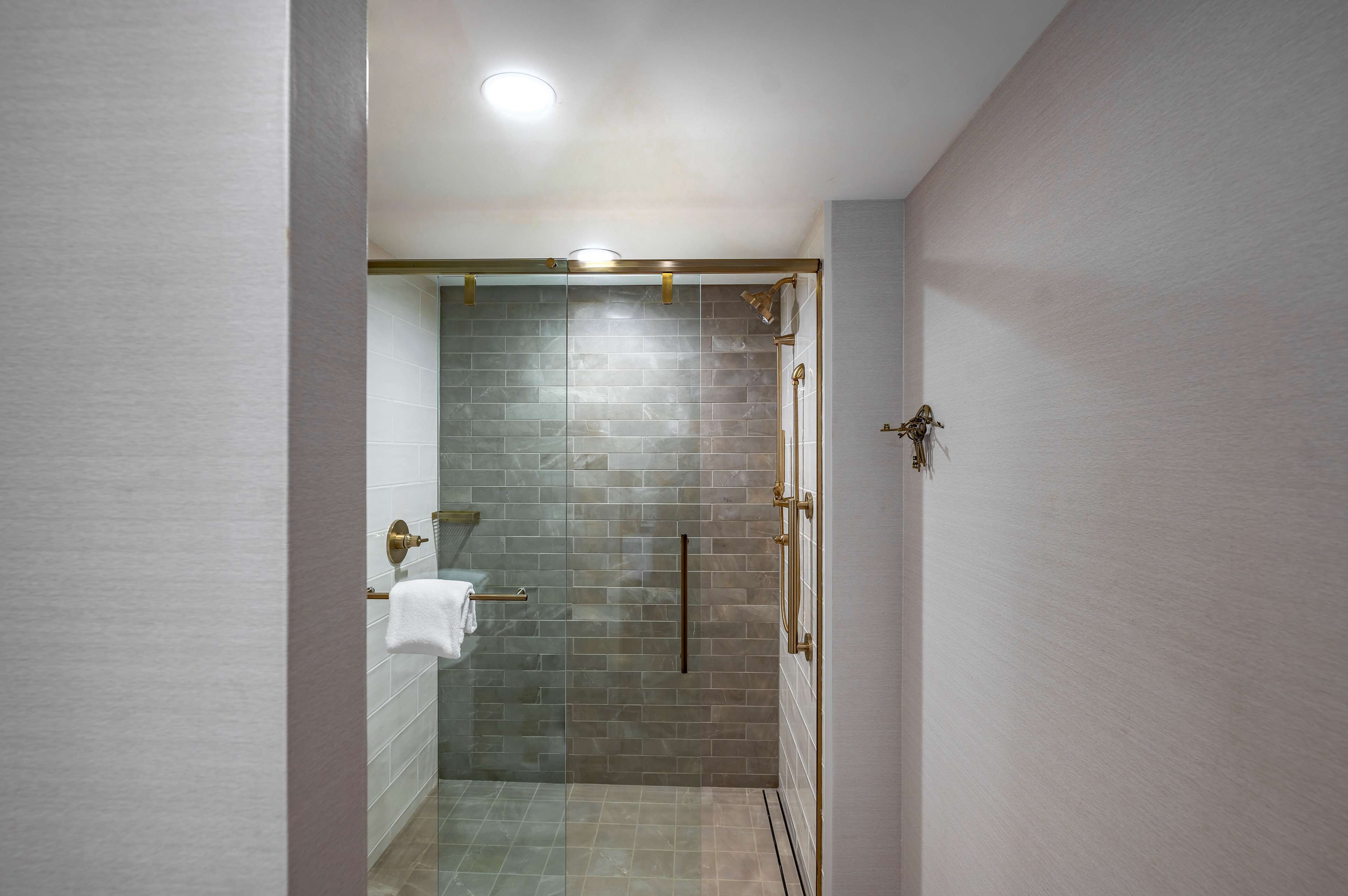 Une salle de bain moderne avec une douche à parois de verre, des murs carrelés et un porte-serviettes.