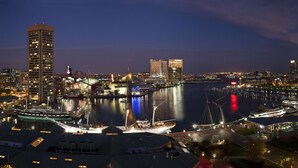 A waterfront cityscape with modern buildings, a marina with sailboats, and a prominent tall building. - Hyatt Regency Baltimore Inner Harbor (Baltimore)