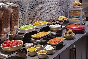 A buffet with various food items and containers.