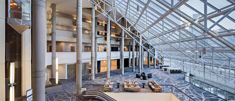 A spacious atrium with a high ceiling, multiple floors, and a central staircase.