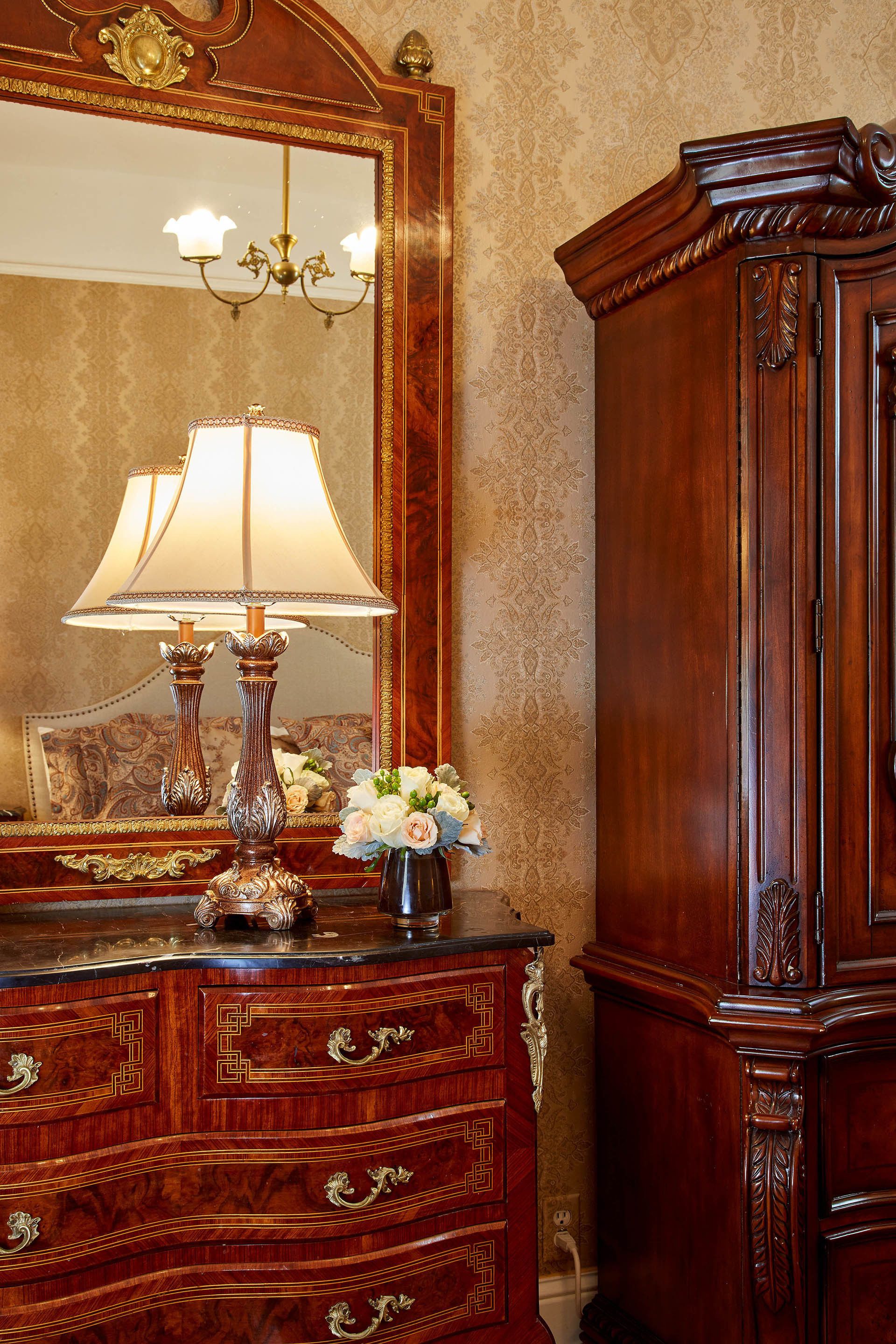 A wooden dresser with drawers and a mirror above it.