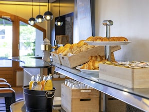 A breakfast buffet with pastries, a coffee station, and a view of the outdoors. - ibis Sion Hotel (Sion)