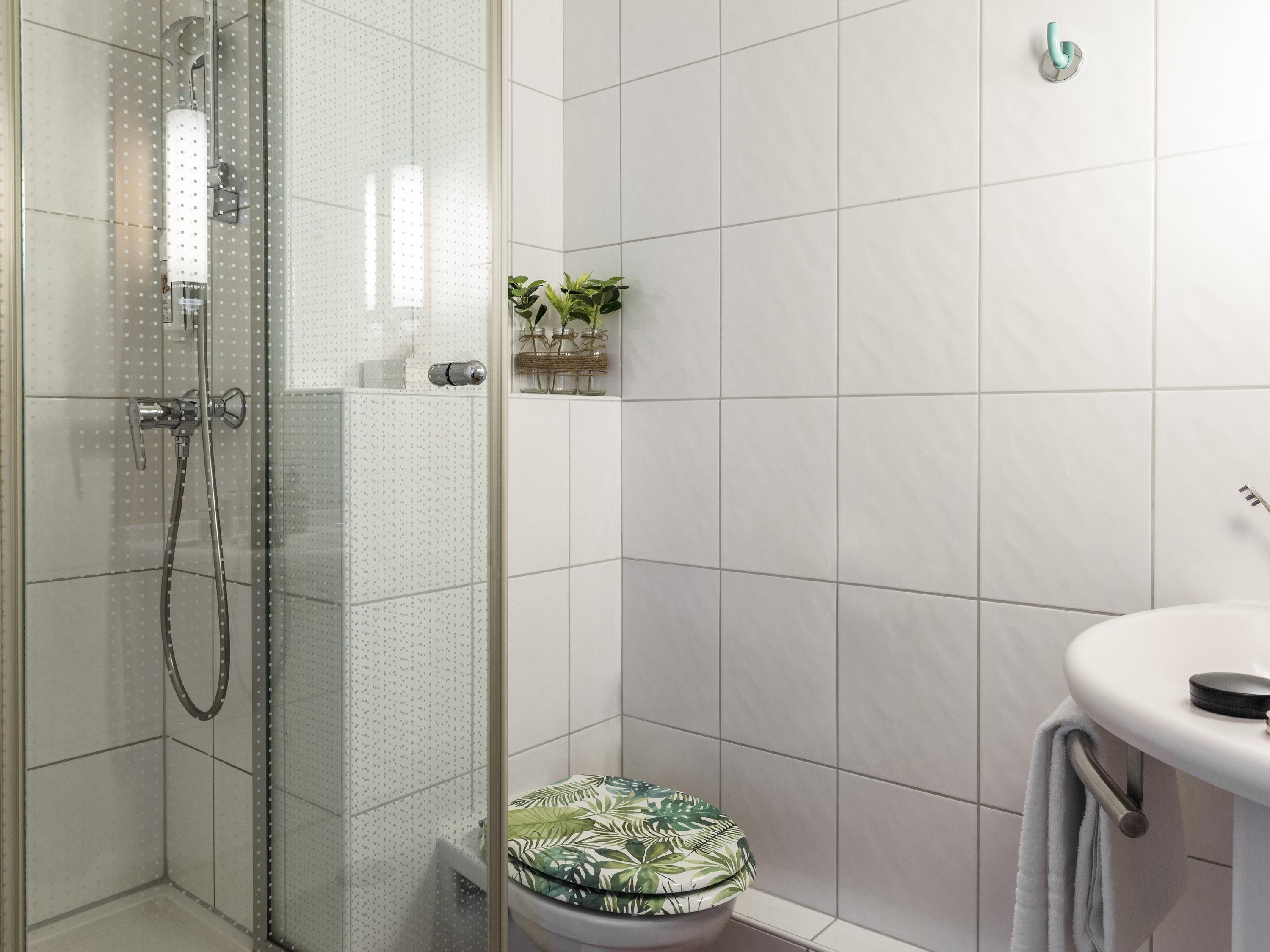 A bathroom with a shower, toilet, and sink.