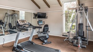 A gym with treadmills, exercise bikes, and weight machines.