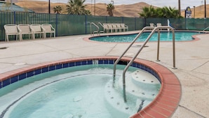 A hot tub with a 3.5 feet depth, surrounded by lounge chairs and a pool. - Days Inn by Wyndham Westley (Westley)