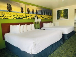 A hotel room with two beds, a green wall, and a large landscape painting. - Days Inn by Wyndham Westley (Westley)