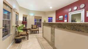 A hotel lobby with a reception desk, seating area, and potted plants. - Days Inn by Wyndham Westley (Westley)
