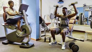 A gym with exercise equipment, including a stationary bike and dumbbells. - Accra City Hotel (Accra)