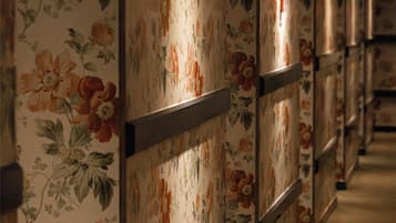 A hallway with floral wallpaper and wooden paneling.