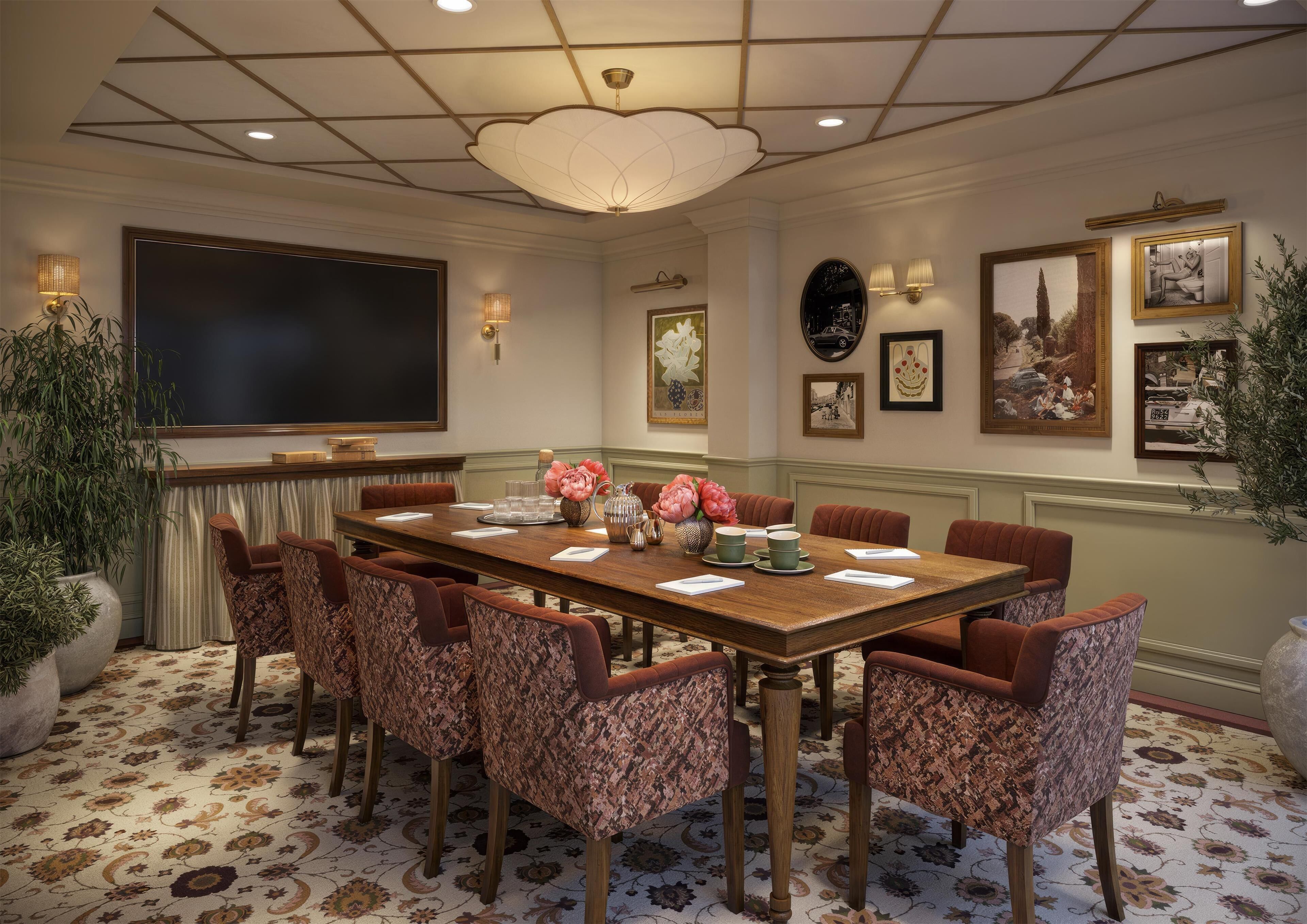 A conference room with a large table, chairs, and a ceiling light fixture.