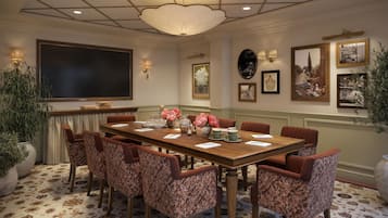 A conference room with a large table, chairs, and a ceiling light fixture.