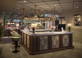 A bar area with a marble countertop, bar stools, and a variety of bottles and glasses.