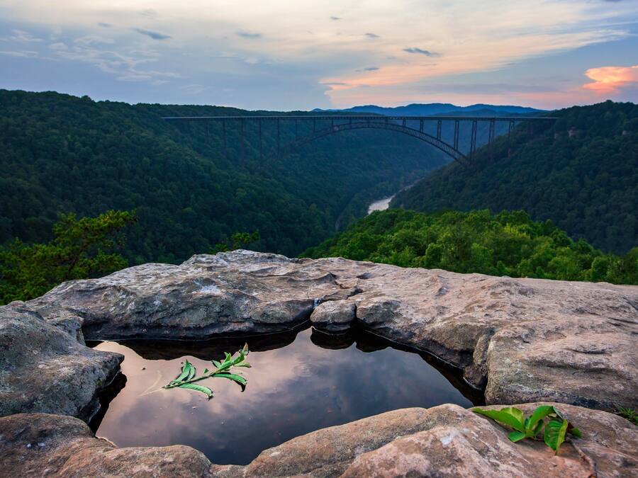 A rocky landscape with a bridge in the distance.