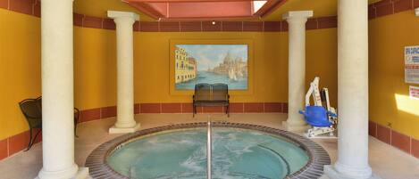 A pool area with a painting of a cityscape, a chair, and a sign indicating a spa capacity of 10 persons.