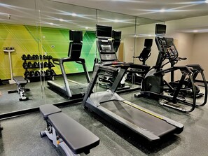 A gym with treadmills, a bench, and dumbbells. - Holiday Inn Rancho Cordova by IHG (Rancho Cordova)