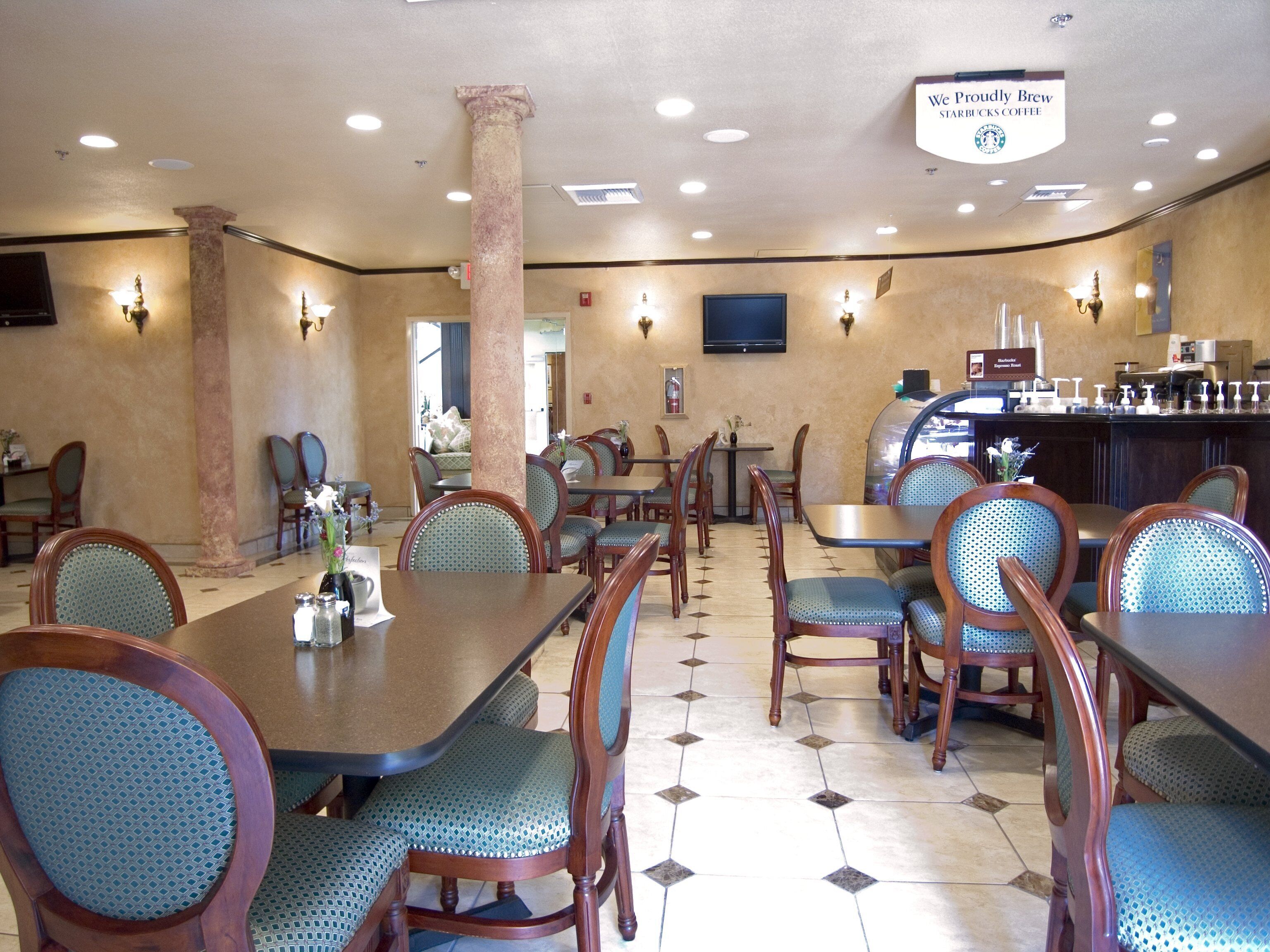 Un restaurant doté de plusieurs tables et chaises, d’un bar et d’une enseigne indiquant qu’il s’agit d’un établissement Starbucks.