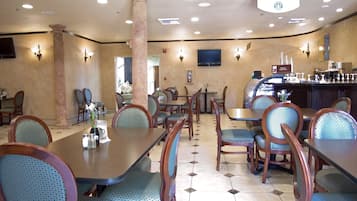 A restaurant with multiple dining tables and chairs, a bar area, and a sign indicating it is a Starbucks Coffee location.