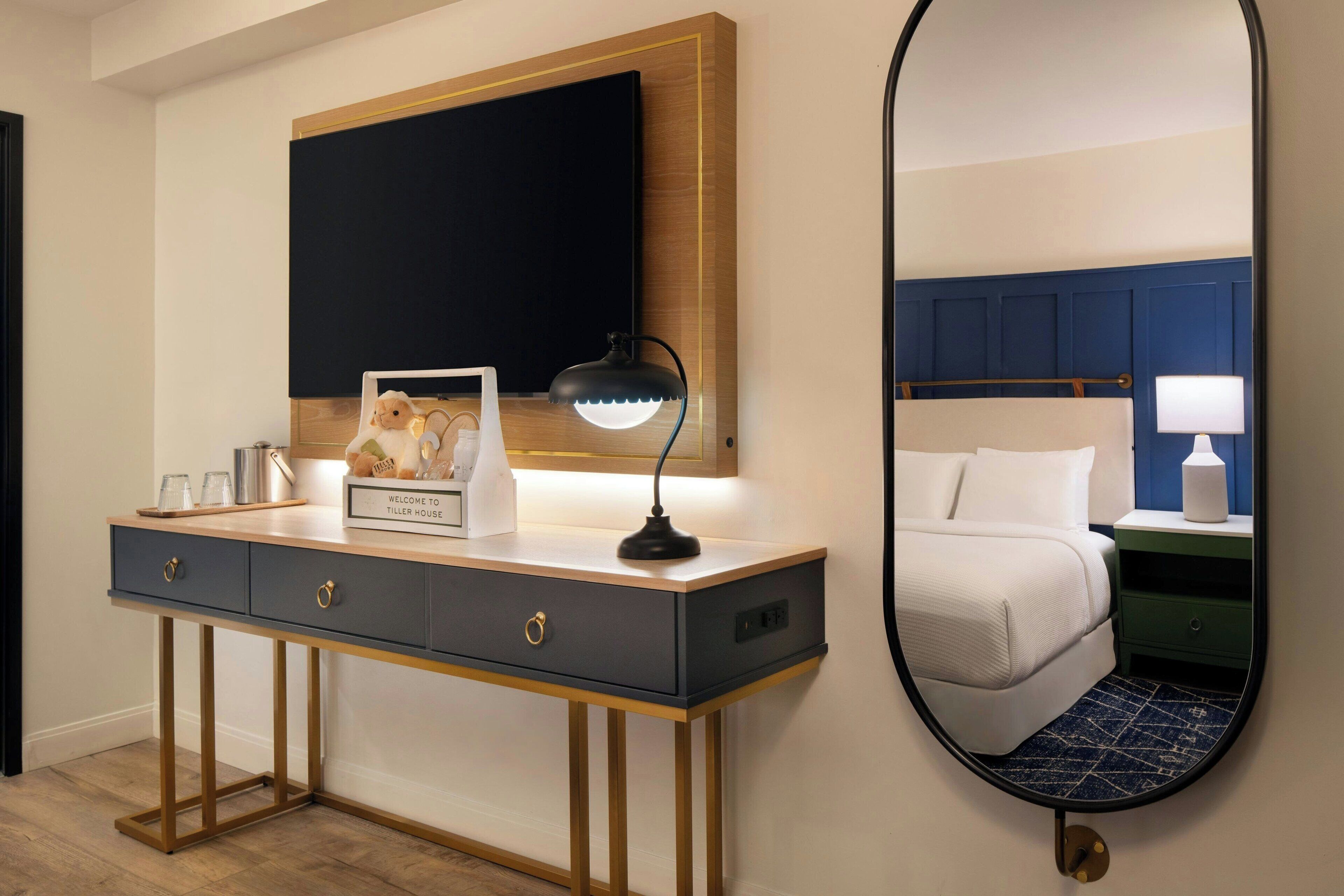 Een hotelkamer met een bureau, een spiegel en een bed.