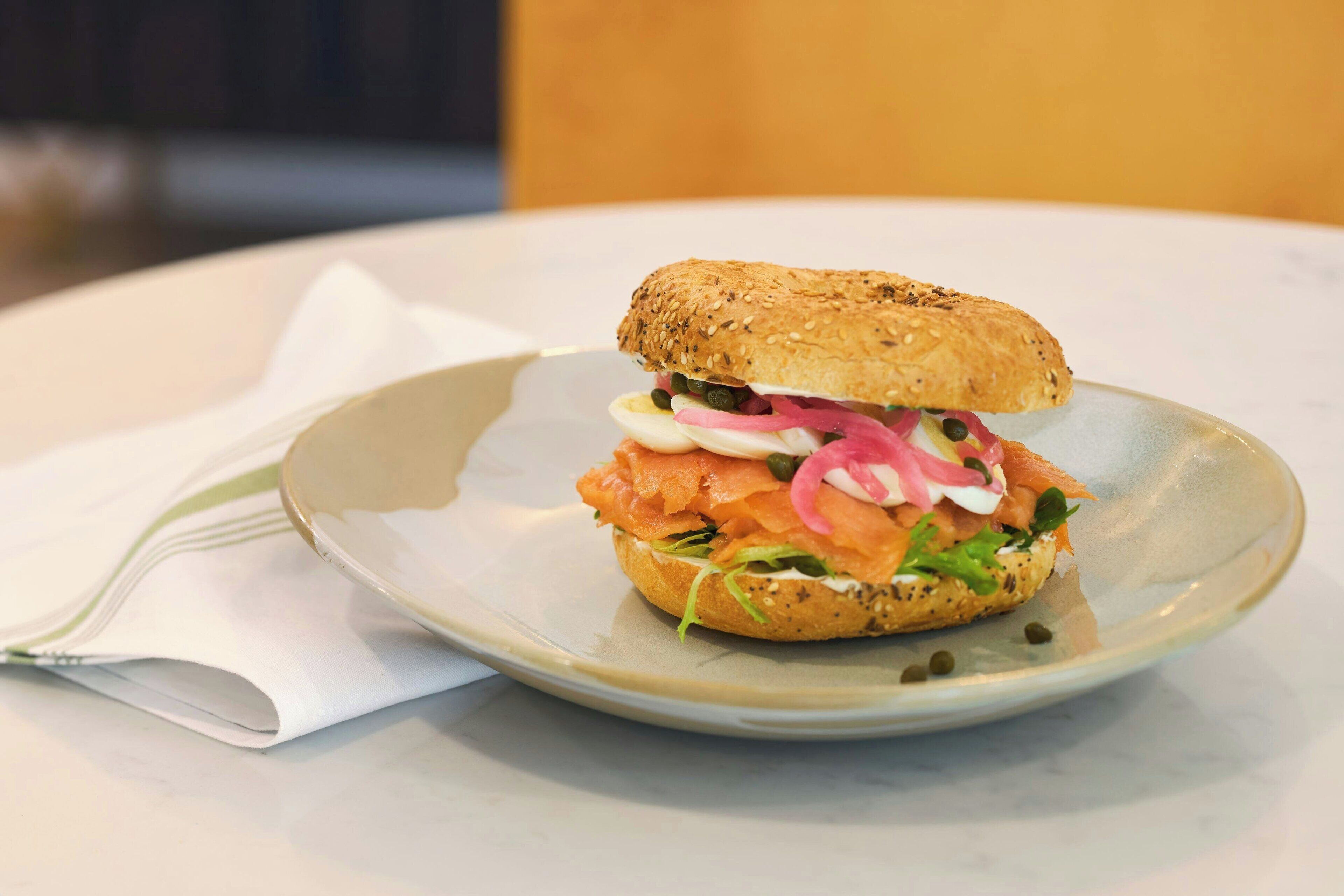 Un sandwich sur une assiette, avec une serviette à côté.