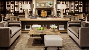 A luxurious lobby with a fireplace, comfortable seating, and a large bookshelf. - Rosewood Mansion on Turtle Creek (Dallas)