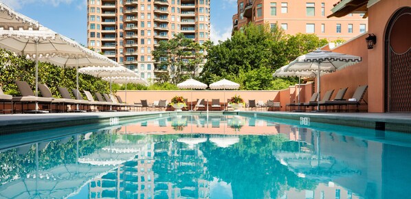 Relax by the serene pool surrounded by lush greenery and modern architecture.