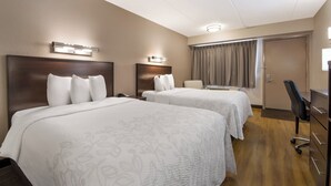 A hotel room with two beds, a desk, a chair, and a door. - Red Roof Inn PLUS+ Nashville Airport (Nashville)