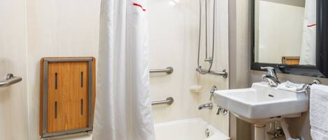 Une salle de bain avec une baignoire, une douche, un lavabo et un miroir.