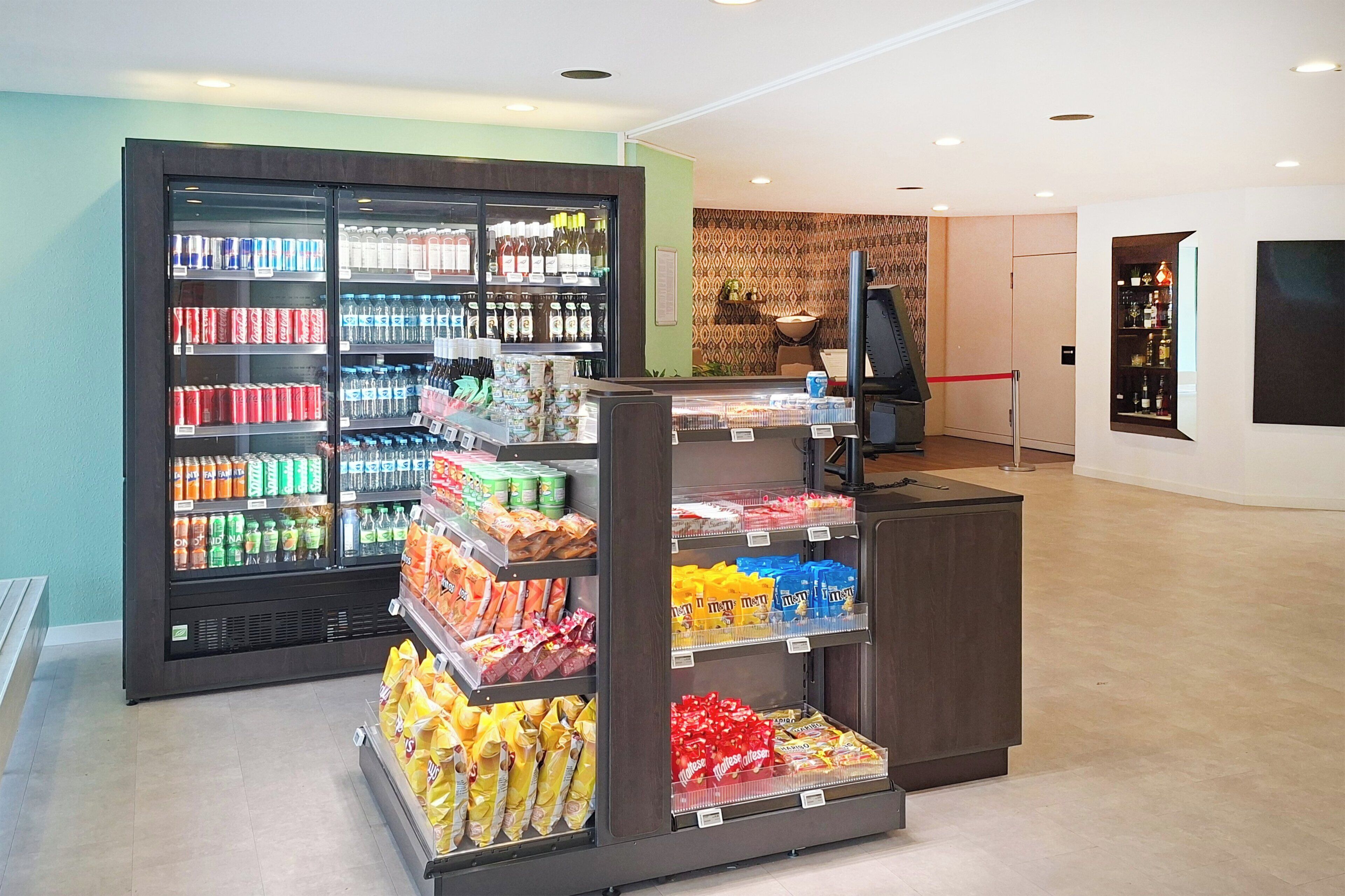 Un supermercado con áreas refrigeradas y estantes repletos de aperitivos y bebidas.