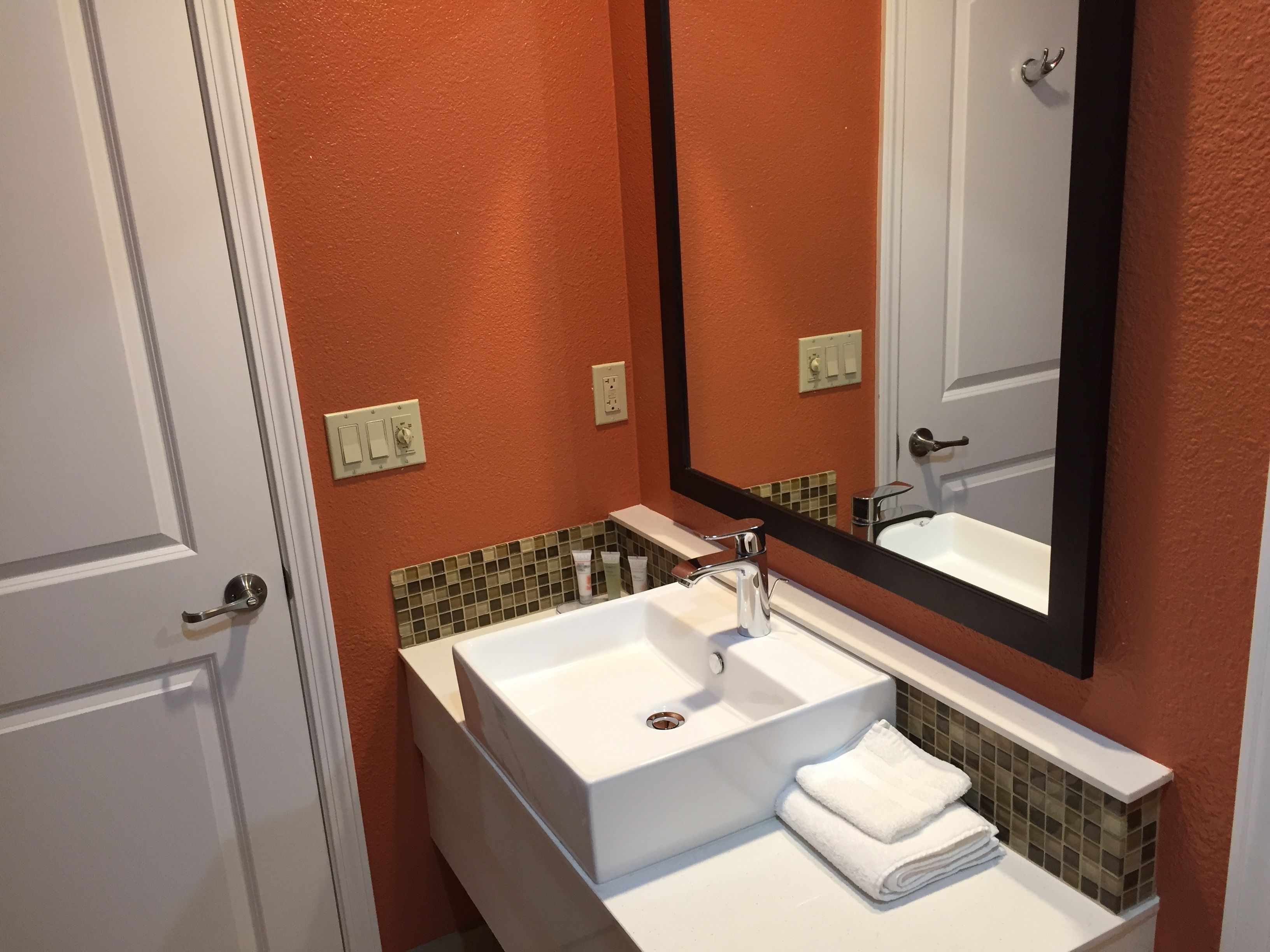 A bathroom with a white sink, a mirror, and a towel rack.