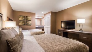 Una habitación de hotel con una cama grande, televisión, escritorio y espejo.