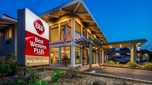 Un hotel Best Western Plus con un diseño moderno, que incluye una entrada cubierta y un área ajardinada al frente.