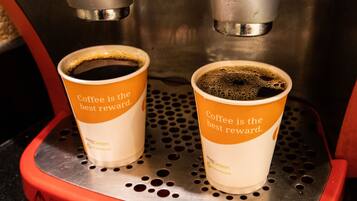 Deux tasses à café sur une machine à café, avec l'inscription : « Le café est la meilleure des récompenses. »