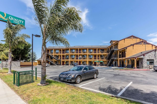 Quality Inn features a two-story building with a parking lot and a signboard.