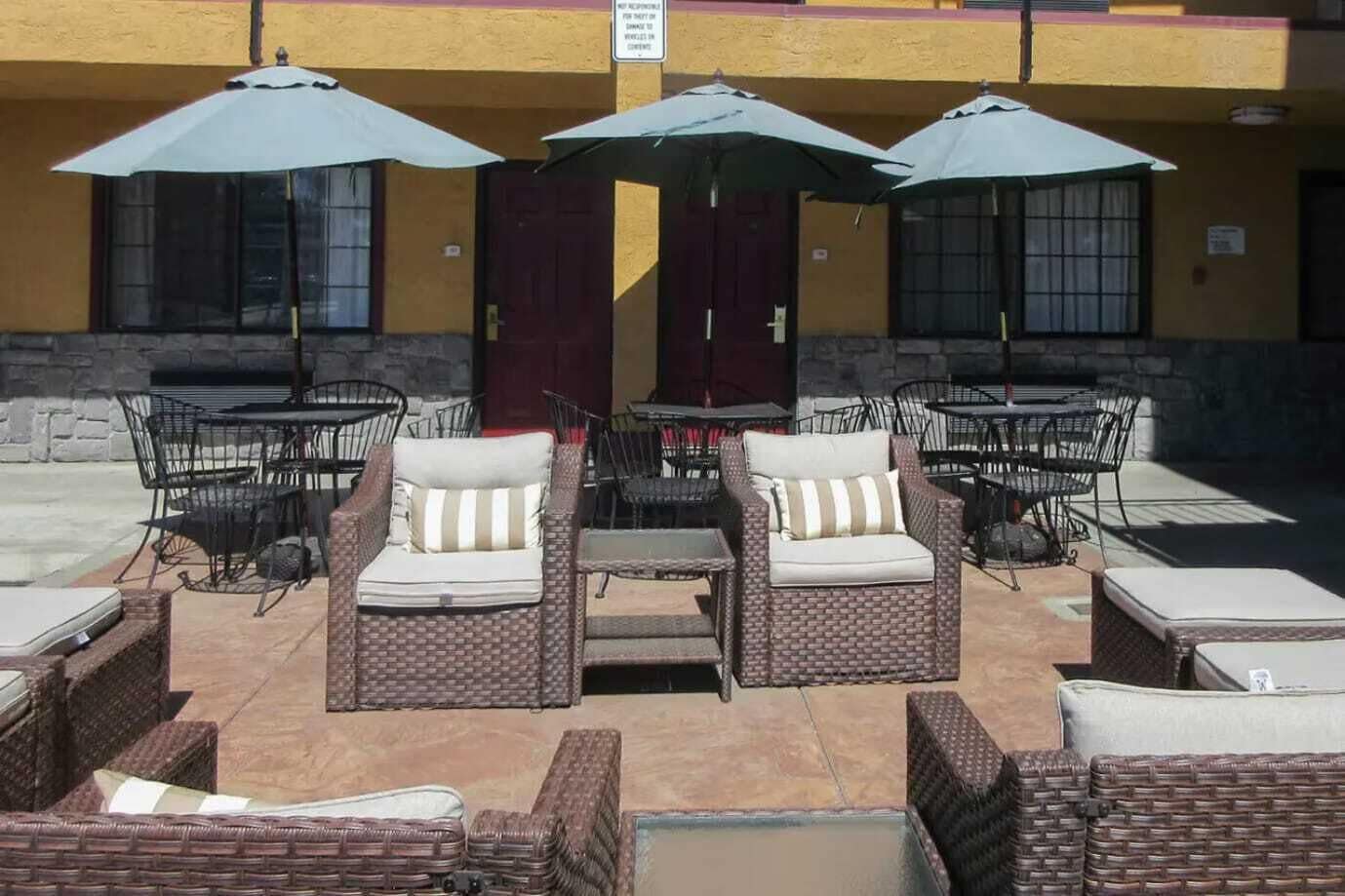 An outdoor seating area with wicker furniture and umbrellas.