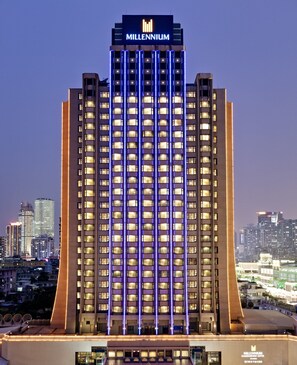 Un hotel alto de diseño moderno, con un llamativo letrero 'Millennium' en la parte superior.
