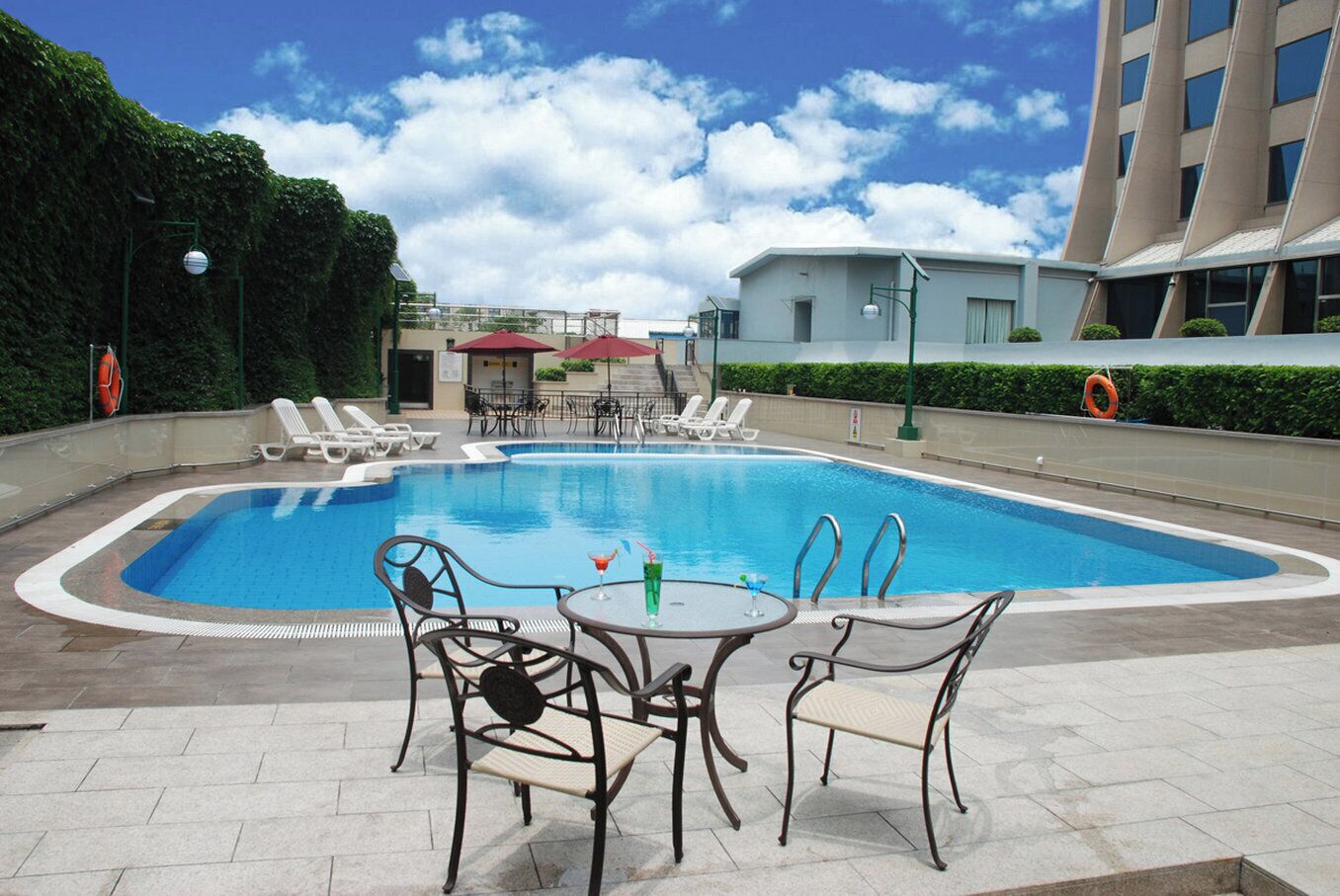Una piscina al aire libre de temporada, sombrillas